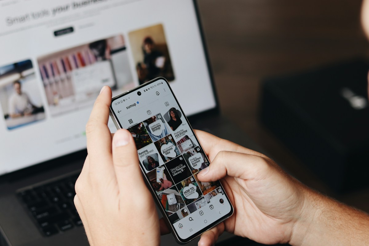 Person using smartphone to browse social media content for TikTok and Meta advertising research